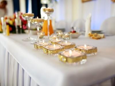 Zastawa weselna z palącymi się świeczkami na stole 2